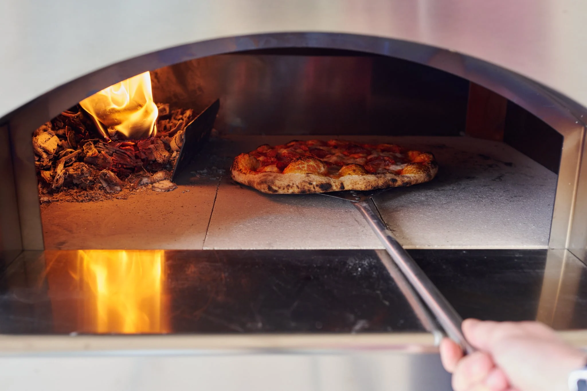 Learn how to use a wood-fired oven for pizzas with a unique, smoky flavor.