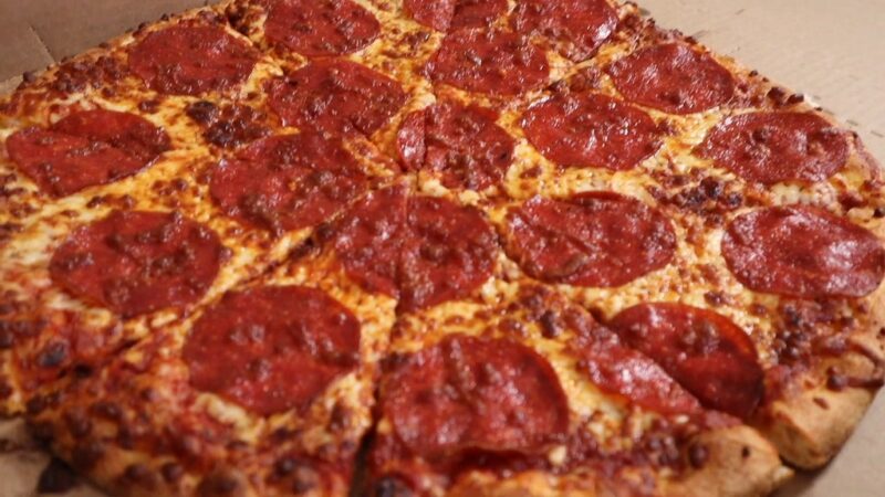 A large pepperoni pizza with a thin crust and crispy edges