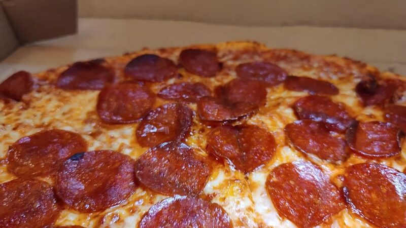 A closer look at an extra-large Brooklyn-style pizza with evenly browned pepperoni slices and golden cheese