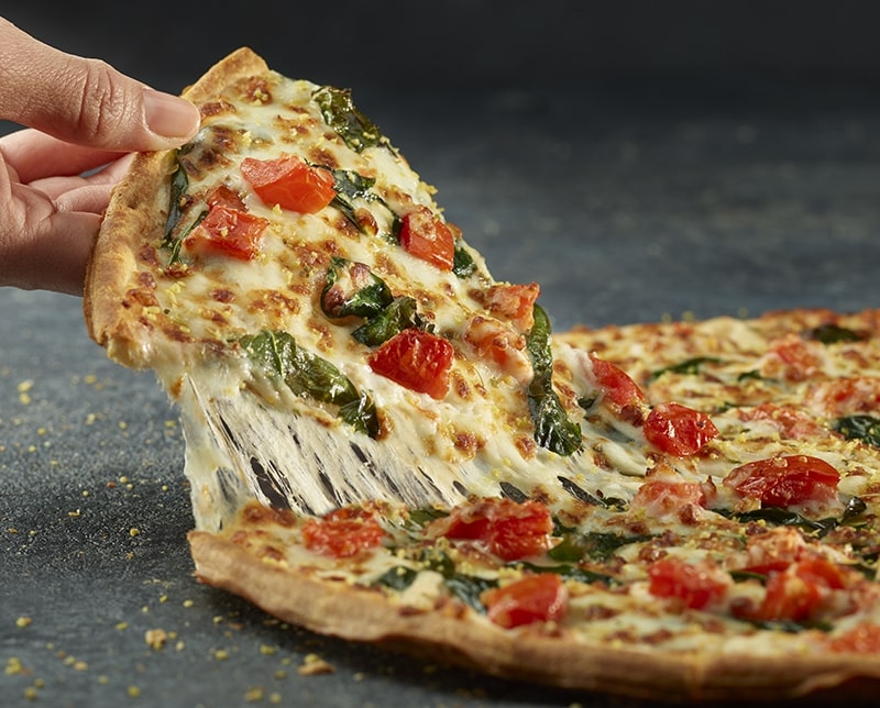 A slice of Alfredo pizza being lifted