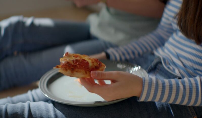 A slice of pizza, held gently in hand, ready to be savored